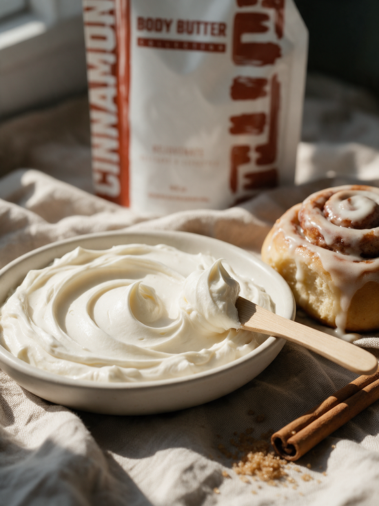 Fluffy whipped Cinnamon Bun body butter swirl beside a fresh cinnamon roll