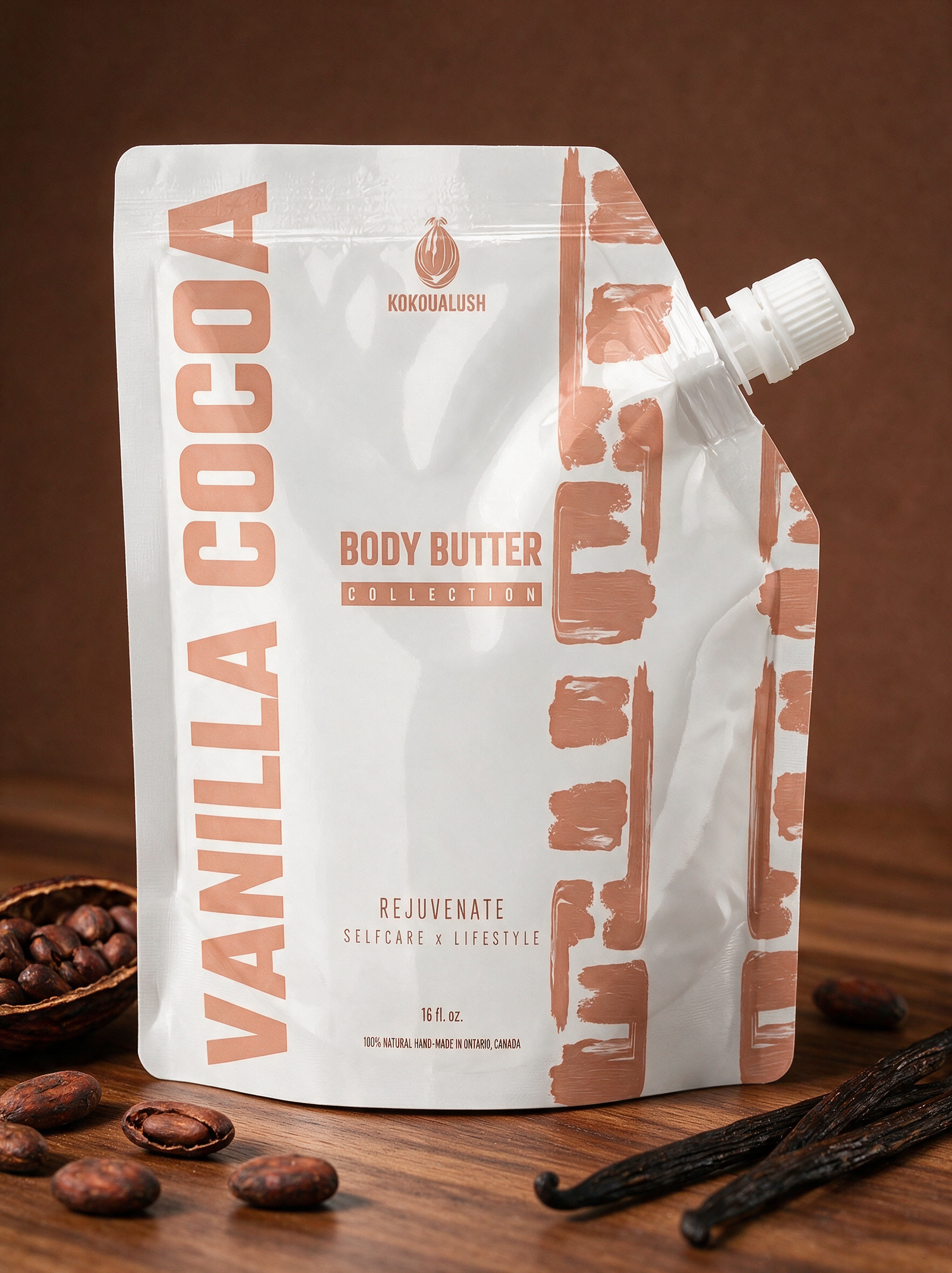 Kokoualush Vanilla Cocoa Body Butter pouch on walnut wood with cocoa beans and vanilla pods