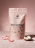 Kokoualush Rosey Coconut Bath Soak pouch on blush linen with rose petals and coconut