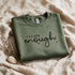 Kokoualush You Are Enough sage green crewneck folded flat-lay on linen with dried lavender