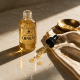 How to use Kokoualush Empress Glow Oil: dropper dispensing on marble with gold silk and flakes