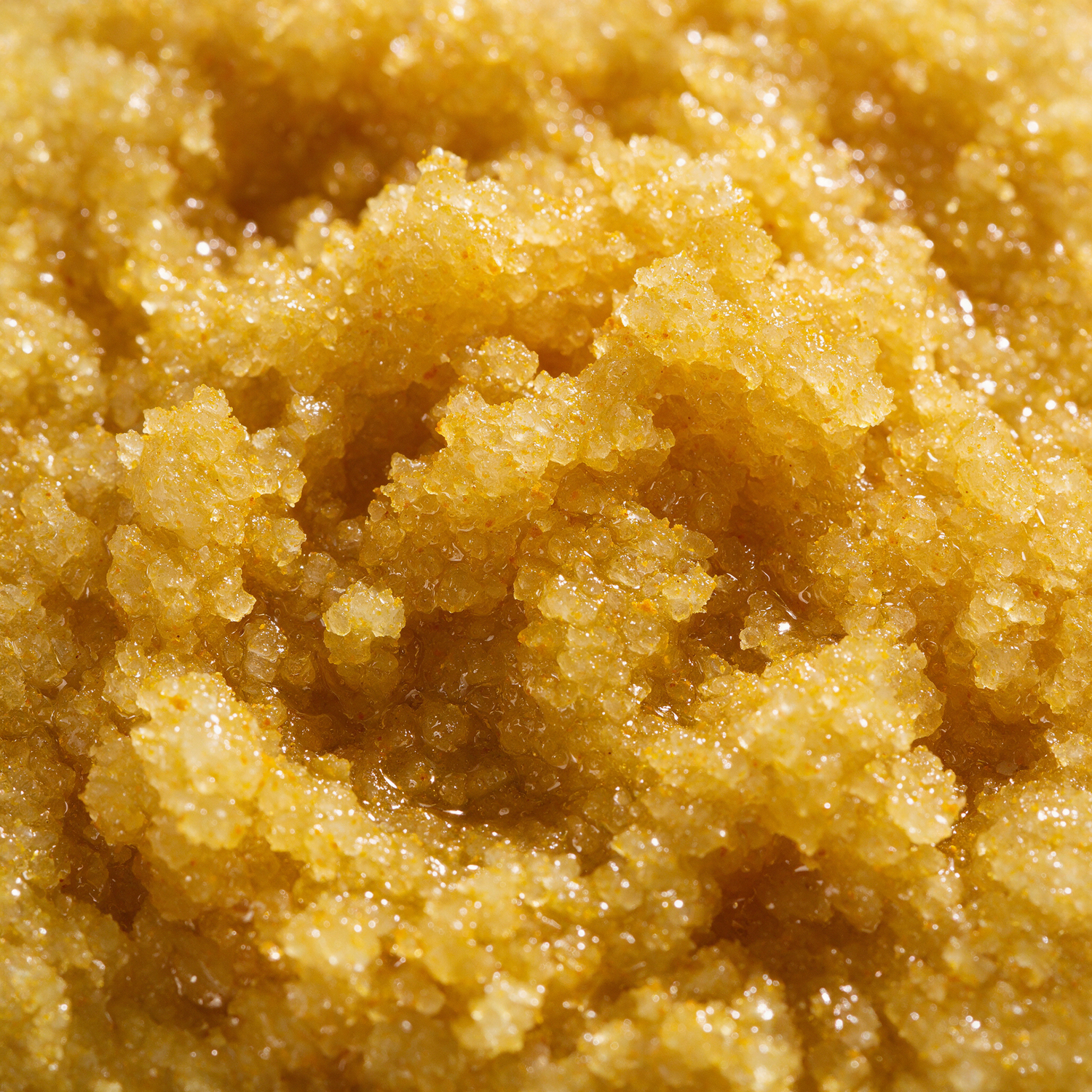 Macro texture of golden turmeric sugar scrub crystals