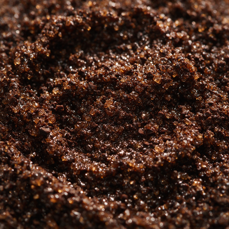 Macro texture of dark coffee sugar scrub with ground coffee and crystals