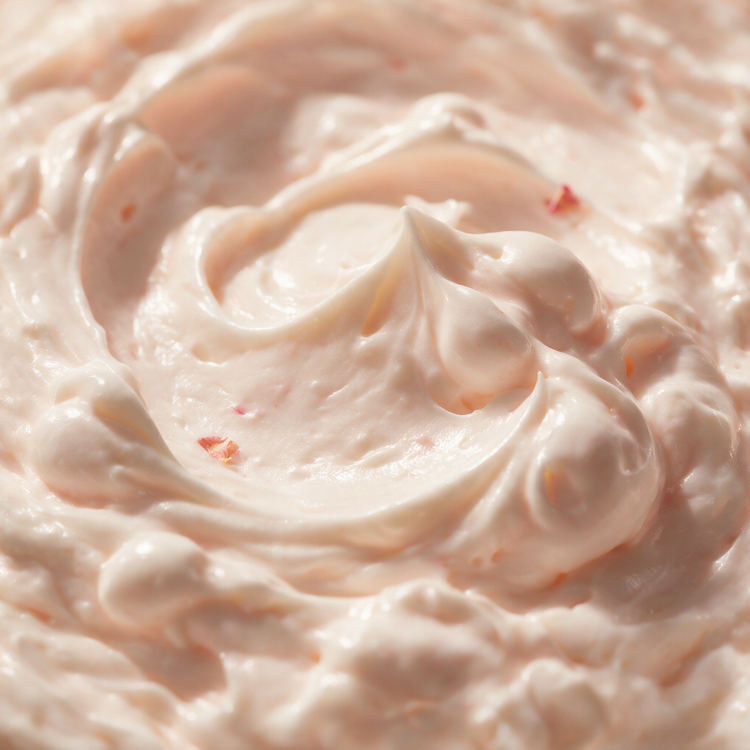 Macro texture of whipped rose body butter peaks with blush tint