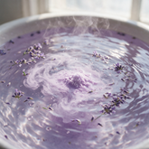 Lavender bath salts dissolving in steamy water with floating lavender
