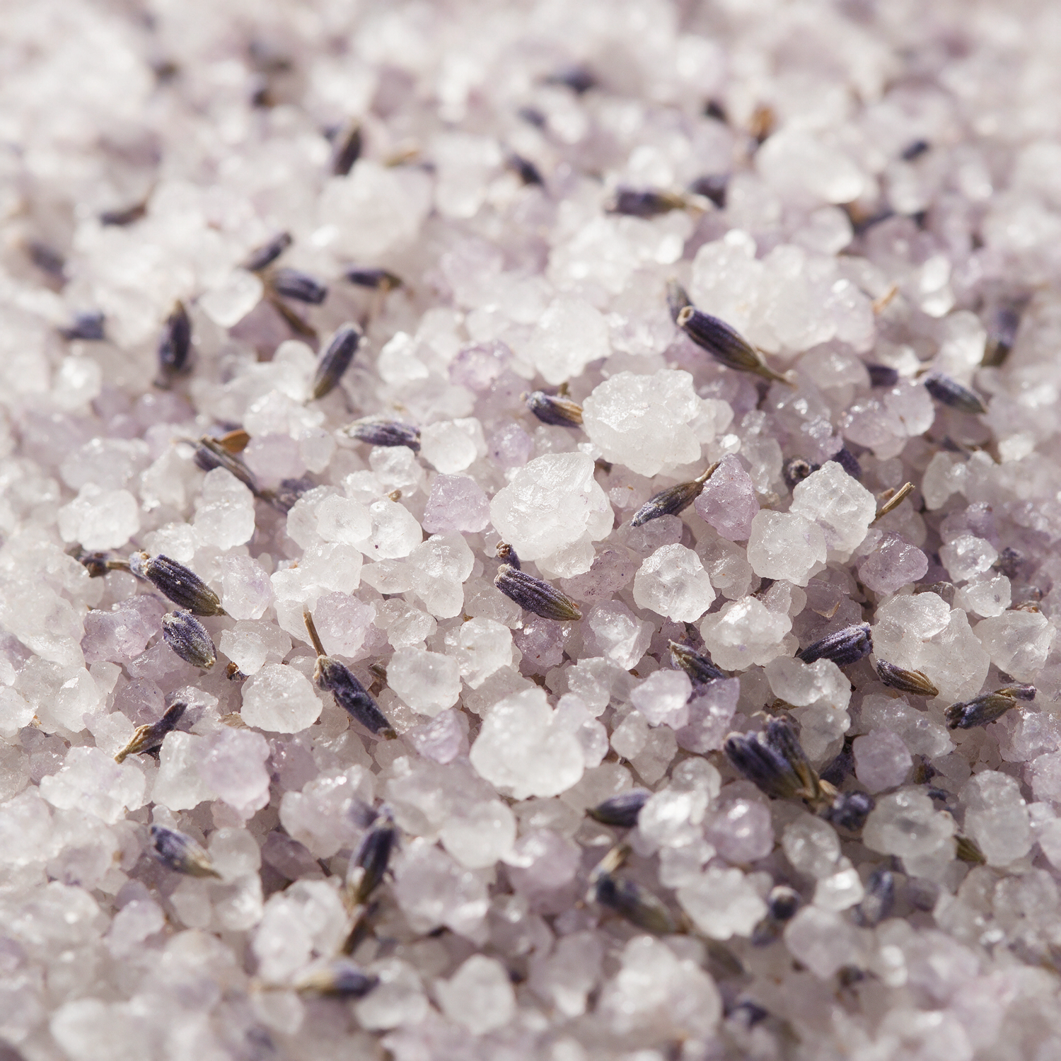 Macro of coarse lavender bath salt crystals with dried buds