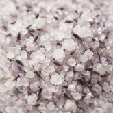 Macro of coarse lavender bath salt crystals with dried buds