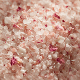 Macro of rose and coconut bath salts with crushed petals