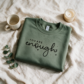 You Are Enough sage crewneck folded and styled with self-care props