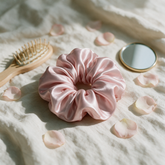 Blush pink silk scrunchie styled with a hairbrush and mirror